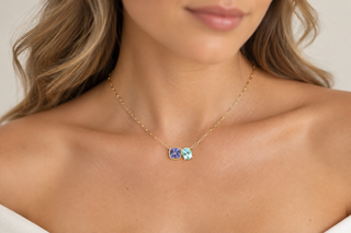 Cushion cut tanzanite and oval aquamarine Duet necklace in 18K yellow gold worn on a model